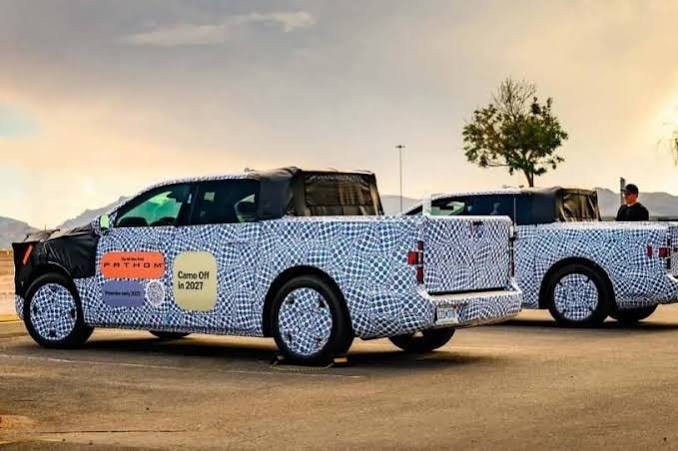 Ford Fathom prototype spy shot — two camouflaged trucks in a parking lot with Coming Off in 2027 signage